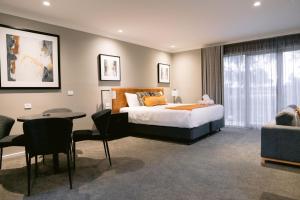 沃加沃加瓦格RSL俱乐部汽车旅馆的一间卧室配有一张床、一张桌子和一张沙发