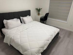 卡尔加里Sun Light Kissed Cozy Suite - Modern Boho Paradise的卧室内的一张带黑色床头板的白色床