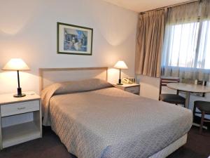 蒙得维的亚特雷斯克鲁塞斯酒店的酒店客房配有一张床铺和一张桌子。