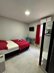 马拉巴Casa de 2 Quartos no Centro的一间卧室配有一张带红色毯子的床