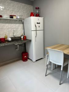 马拉巴Casa de 2 Quartos no Centro的厨房配有白色冰箱和桌子