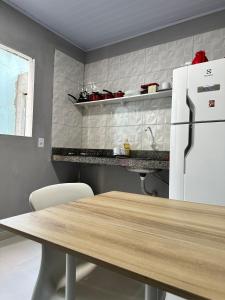 马拉巴Casa de 2 Quartos no Centro的厨房配有桌子和白色冰箱。