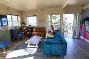悉尼库吉海滩灵猴旅舍的坐在客厅沙发上的女人