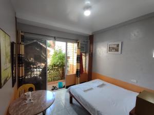 邦劳芒果之家公寓 的客房设有床、桌子和窗户。