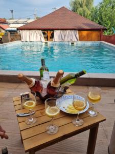 加拉茨Vila Mario的游泳池旁配有酒瓶和玻璃杯的桌子
