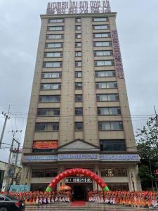 西哈努克SENNA SUNSHINE INTERNATIONAL HOTEL的前面有游行的大建筑