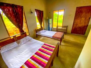 GalewelaNelumgala Cottage -Village Experience的一间卧室设有两张床和窗户。