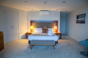 派西亚海滨套房 - 历史公寓式酒店的一间卧室配有一张大床、两张桌子和两盏灯。