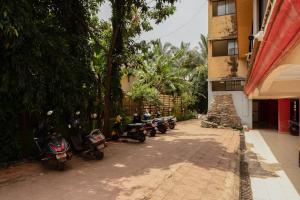 瓦加托Mossy - Aesthetic 2BHK Apartment - Vagator, Goa By StayMonkey的停在大楼旁边的一排摩托车