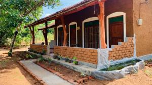 锡吉里亚Sigiriya Chena Villa的砖屋,外边有植物门廊