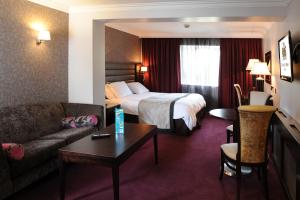 穆林加尔马林加格雷维尔武器酒店的酒店客房配有床、沙发和桌子。