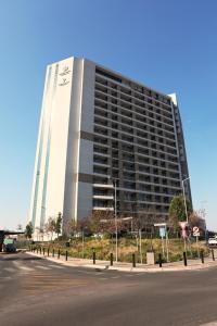 比勒陀利亚Menlyn Trilogy - 2 Bedroom & Great Views - No Loadshedding的街道边的大建筑