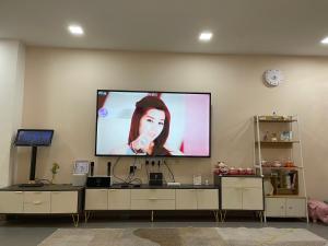蕉赖Double storey and half 4r3b karaoke lami的墙上的平面电视,上面有女人