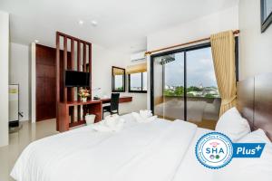 普吉镇The Topaz Residence Phuket Town的卧室配有一张白色大床和一张书桌
