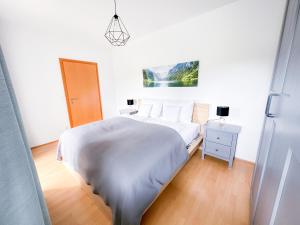 巴特格莱兴贝格Idyllische Wohnung mit Garten!的一间白色卧室,配有床和床头柜