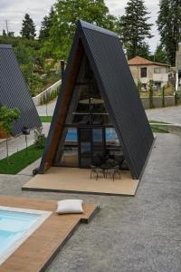 帕弗兰尼Pavliani4rest - Luxury Cabins的三角屋,设有桌椅,毗邻游泳池
