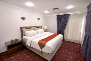 科威特科威特卡尔顿塔酒店的一间卧室配有一张大床和紫色窗帘