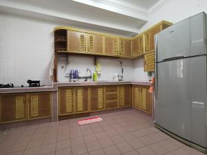 关丹DIY Palm Court 3BR Apartment, 7 Guests的厨房配有木制橱柜和不锈钢冰箱。