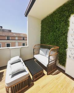 OrsognaNontiscordardime的阳台配有2把藤椅和绿色墙壁