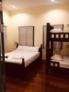 董里Thunyaporn Hostel的铺有木地板的客房内配有两张双层床。