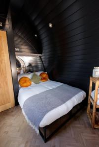 AchmelvichNorth Coast 500 Pods的卧室配有一张位于黑色墙壁上的床铺