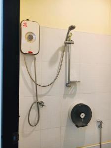 董里Thunyaporn Hostel的浴室设有淋浴,墙上装有水管