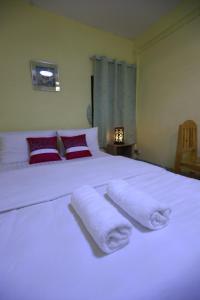 曼谷OYO 75440 Nara Hostel的卧室配有白色床和毛巾