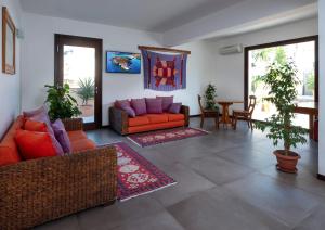 兰佩杜萨Moresco Resort的客厅配有橙色沙发、桌子和椅子