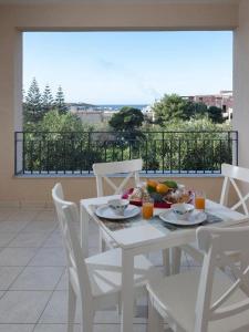 兰佩杜萨Moresco Resort的阳台上配有白色桌椅和食物