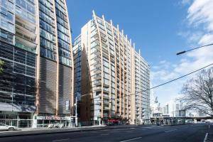 墨尔本Flinders Street Simplicity Overlooking the Yarra的一条空荡荡荡的城市街道,阳光明媚,有高楼