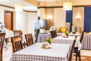 弗罗茨瓦夫皮亚斯特弗罗茨瓦夫中枢酒店的餐厅设有两张带紫色和白色桌布的桌子