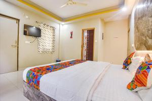 GoaFabExpress Laxmi Empire, Siolim的一间卧室设有一张大床和一台墙上的电视。