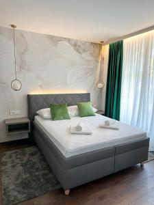 萨格勒布利迪雅旅馆的一间卧室配有一张大床和两个绿色枕头