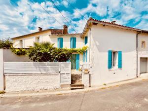 Saint-Fort-sur-GirondeVintage Guesthouse的白色的房子,设有蓝色的窗户和栅栏