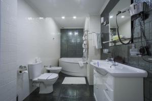 基辅基辅酒店的白色的浴室设有卫生间和水槽。