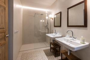 卡塞雷斯Casa Pizarro Hotel的一间带两个盥洗盆和淋浴的浴室