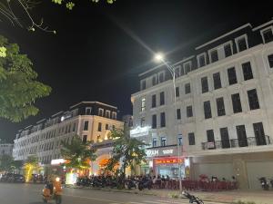 海防Basic Guest House Hải Phòng的一群人晚上坐在建筑物外面