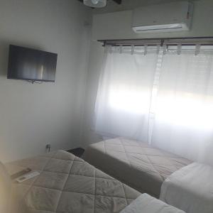 巴尔卡塞Departamento sierras Balcarce的配有2张床的客房设有窗户和电视。