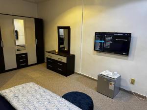 达喀尔Chambres d'hôte centre ville的一间卧室配有一张床、一台电视和一面镜子