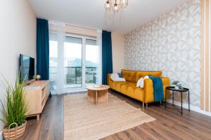 布达佩斯WaterFront City Apartments by UrbanRent的客厅设有黄色沙发和电视