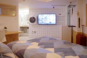 广州同古舍博物馆酒店的卧室配有一张床,墙上配有电视。