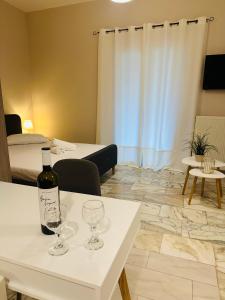 卡诺尼Venetian Gem Central Corfu Retreat的桌子上一瓶葡萄酒和酒杯