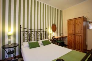 马拉加马拉加住宿加早餐旅馆的一间卧室配有一张绿色和白色条纹的床