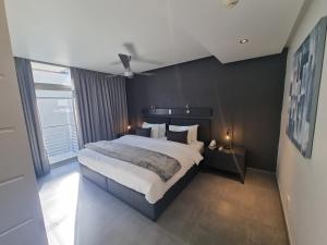 开普敦大西洋事理精品酒店的一间卧室设有一张大床和一个大窗户