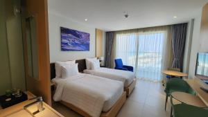 金兰市Home Seview at Cam ranh Nha Trang Aparment的酒店客房设有两张床和电视。