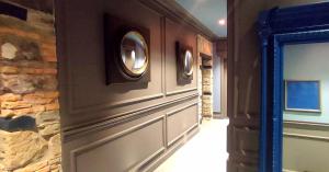 的里雅斯特FORVM bijoux ROOMS的走廊上设有石墙和两面圆形镜子