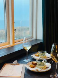 阿灵厄The Falcon Hotel的一张桌子,上面放着两杯白葡萄酒和食物