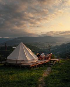 DseghAlereks Mountain Camping的几个人坐在帐篷旁边的椅子上