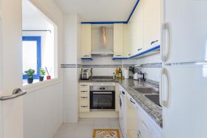 马尼尔瓦Duquesa Suites Manilva的厨房配有白色橱柜和蓝色色调