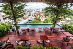 胡志明市银城延酒店的一个带桌椅的庭院和一个游泳池